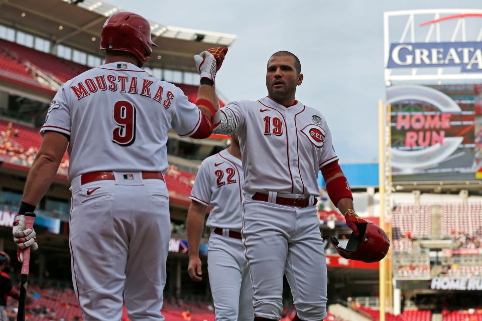 Cincinnati Reds designated hitter Joey Votto (19) and first baseman Mike Moustakas (9) fist bump after Votto’s three-run home run in the first inning of the MLB National League game between the Cincinnati Reds and the Washington Nationals at Great American Ball Park in downtown Cincinnati on Thursday, June 2, 2022.