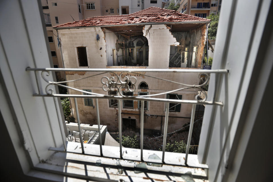 A heritage house that was destoyed by Aug. 4 explosion that hit the seaport of Beirut, is seen through a broken window of other heritage house, in Beirut, Lebanon, Tuesday Aug. 25, 2020. In the streets of Beirut historic neighborhoods, workers are erecting scaffolding to support buildings that have stood for more than a century - now at risk of collapse after the massive Aug. 4 explosion that tore through the capital. (AP Photo/Hussein Malla)