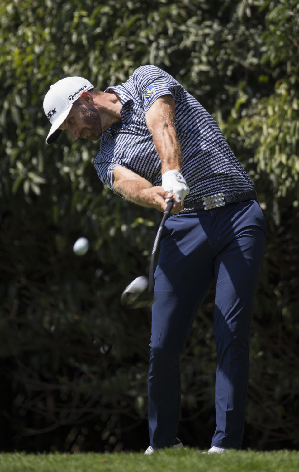 U.S. golfer Dustin Johnson chips the ball into the second hole during the WGC-Mexico Championship at the Chapultepec Golf Club in Mexico City, Sunday, Feb. 24, 2019. (AP Photo/Christian Palma)