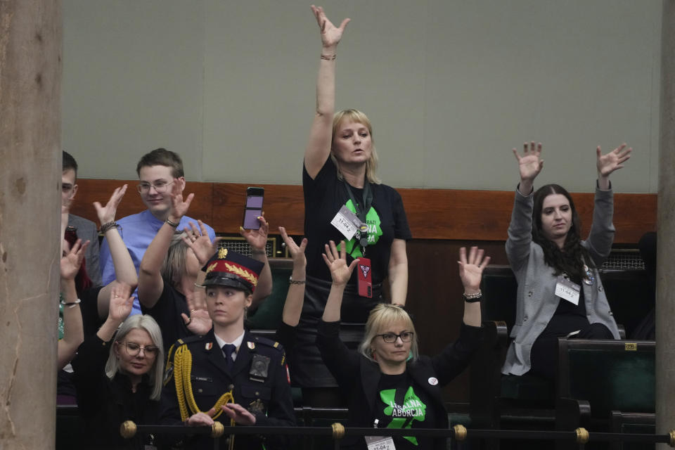 Abortion rights activists react during a debate in the Polish parliament from the gallery of the assembly, in Warsaw, Poland, on Thursday April 11, 2024. The traditionally Catholic nation has one of the most restrictive laws in Europe — but the reality is that many women terminate pregnancies at home with pills mailed from abroad. (AP Photo/Czarek Sokolowski)