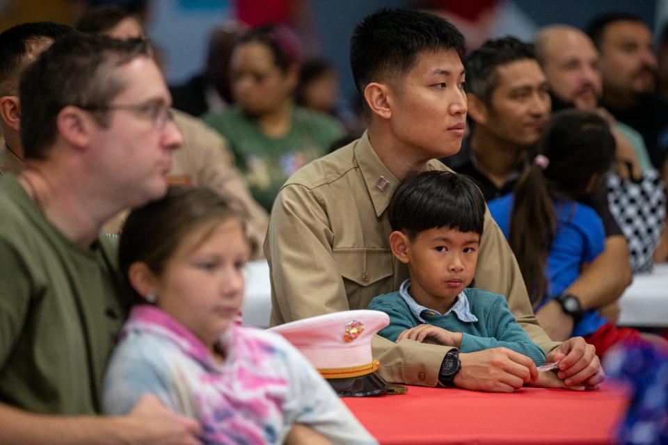 Kindergarten student Alec Bae, 5, and Yohan Bae, a captain in the Marines, watch speakers at Kolda Elementary School's 10th anniversary and Veterans Day celebration on Nov. 7, 2022, in Corpus Christi, Texas.