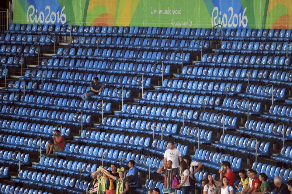 2016 Rio Olympics - Athletics - Preliminary - Men's High Jump Qualifying Round - Group A - Olympic Stadium - Rio de Janeiro, Brazil - 14/08/2016. Spectators sit among empty seats during athletics events. REUTERS/Dominic Ebenbichler FOR EDITORIAL USE ONLY. NOT FOR SALE FOR MARKETING OR ADVERTISING CAMPAIGNS.