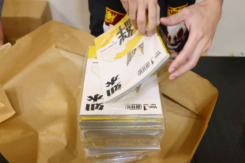 A staff prepares the Flow HK magazine to ship abroad at their office in Taipei