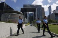 Policemen patrol outside Legislative Council (L) and government headquarters (back) in Hong Kong, China June 16, 2015. REUTERS/Bobby Yip