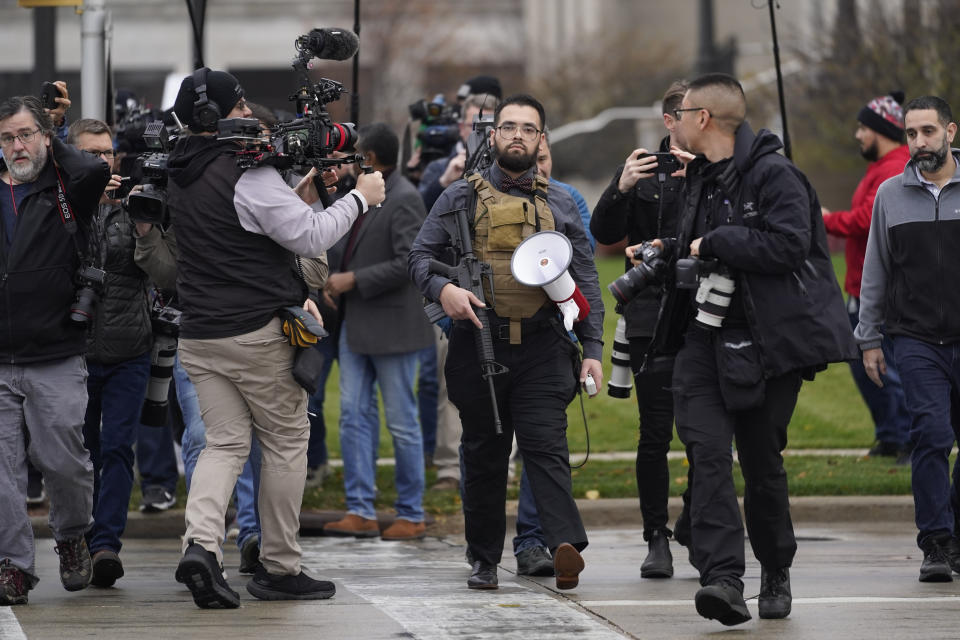 A protester carrying a rifle leaves the the Kenosha County Courthouse after speaking with Kenosha County Sheriffs Department officers, Wednesday, Nov. 17, 2021 in Kenosha, Wis., during the Kyle Rittenhouse murder trial. Rittenhouse is accused of killing two people and wounding a third during a protest over police brutality in Kenosha, last year. (AP Photo/Paul Sancya)