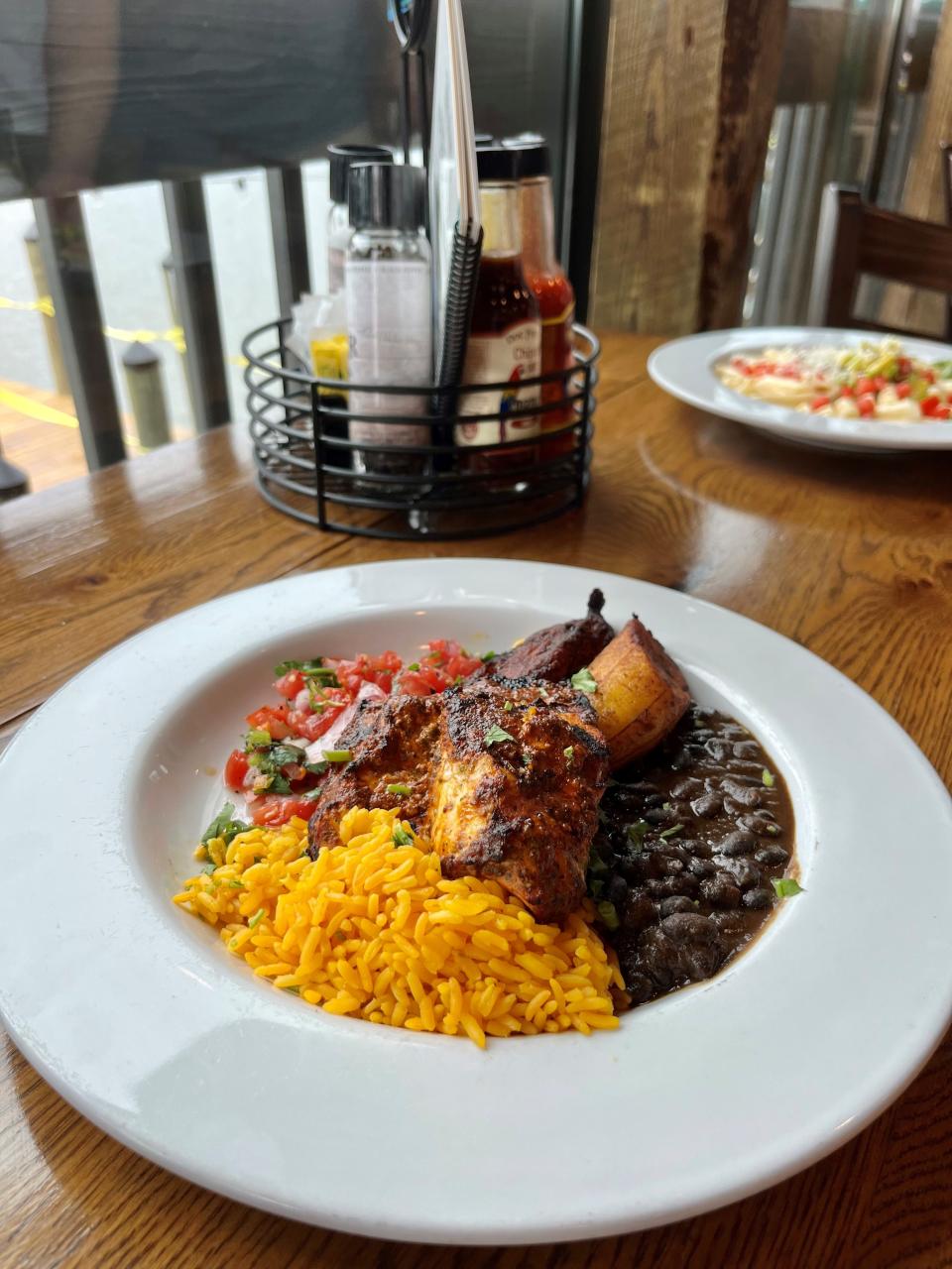 The new achiote redfish bowl at Doc Ford's on Fort Myer Beach comes with char grilled marinated redfish, black beans, yellow rice, plantains and homemade pico.