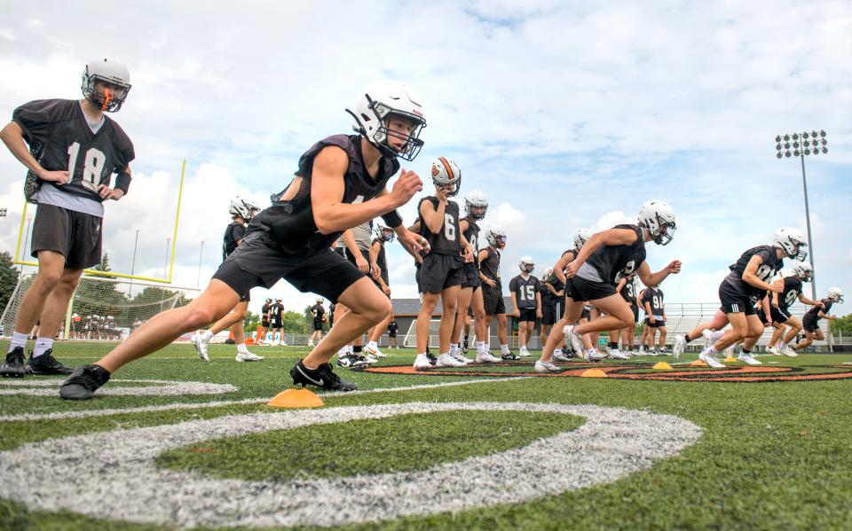 Washington football players work through drills on the official first day of high school football practice Monday, Aug. 7, 2023 at Washington Community High School.