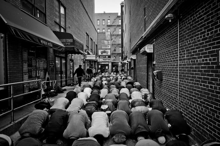 <p>Friday prayer at Darul Hidayah Mosque in Little Bangladesh section of Jackson Heights, Queens, N.Y. Worshipers spilled over to the alley outside the mosque on 73rd Street. (Photo: Yunghi Kim/Contact Press Images) </p>