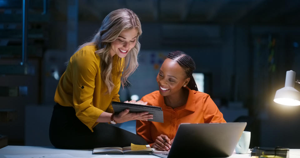 two women coworkers looking at a tablet