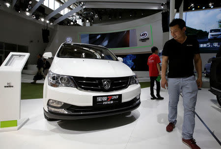 A visitor walks past a Baojun 730 model from SAIC-GM-Wuling Automobile presented the during Auto China 2016 auto show in Beijing, China, May 4, 2016. REUTERS/Jason Lee