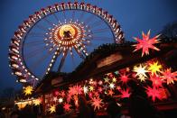 BERLIN, GERMANY - NOVEMBER 28: Visitors walk past a stall selling illuminated Christmas stars at the annual Christmas market at Alexanderplatz two days after the market opened on November 28, 2012 in Berlin, Germany. Christmas markets, with their stalls selling mulled wine (Gluehwein), Christmas tree decorations and other delights, are an integral part of German Christmas tradition, and many of them are opening across Germany this week. (Photo by Sean Gallup/Getty Images)