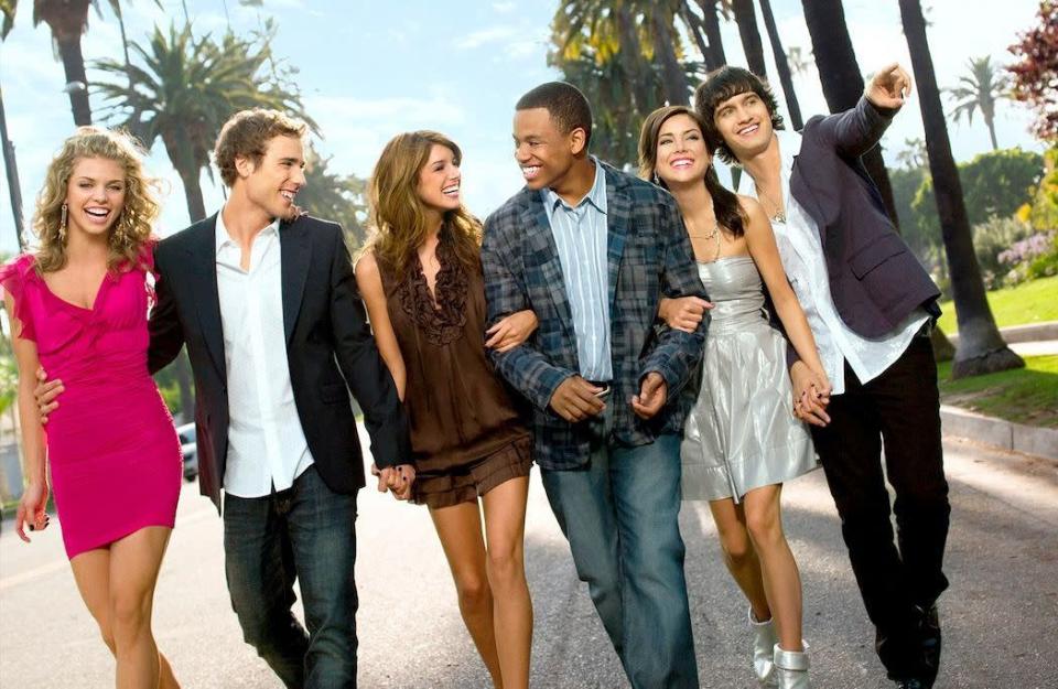 On s’est souvent demandé ce que sont devenus les stars de « Beverly Hills 90210 », mais quid des acteurs qui les ont succédés quelques années plus tard ? En septembre 2008, une nouvelle série pour adolescents voit le jour sur la chaîne américaine The CW. Baptisée « 90210 Beverly Hills : Nouvelle Génération », elle met en scène – comme son nom l’indique – une nouvelle flopée de personnages et s’inscrit dans la parfaite lignée de son aînée, série culte des années 90. Normal, puisque les créateurs restent les mêmes (Rob Thomas, Jeff Thomas et Gabe Sachs), que les dramas s’enchaînent à une allure folle et que l’ambiance sea, sex and sun de la Californie n’a pas bougé d’un palmier. Le petit plus ? Quelques protagonistes du programme original s’invitent dans cette série dérivée hautement addictive. De quoi plaire aux nostalgiques et séduire les jeunes téléspectateurs.Une série culte pour toute une générationDiffusée entre 2008 et 2013, « 90210 Beverly Hills : Nouvelle Génération » ne tarde pas à débarquer sur le petit écran français. Inscrite dans la grille des programmes de M6, la série migre ensuite sur plusieurs chaînes du groupe telles que Téva et W9 avant d’être reléguée sur 6ter. Pendant cinq saisons et environ cent-quatorze épisodes, les téléspectateurs suivent assidûment les tribulations d’une bande de lycéens de West Beverly. S’il ne parvient à détrôner l’iconique « 90210 Beverly Hills » portée jadis par Shannen Doherty, Jennie Garth ou le regretté Luke Perry – décédé en mars 2019 -, le teen drama des années 2000 arrive tout de même à conquérir les cœurs de toute une génération. Histoires d’amour, trahisons et autres déboires adulescents : les rebondissements ne manquent pas. Mais depuis l’arrêt du programme, il y a maintenant neuf ans, que sont devenus les acteurs qui en ont fait le succès ? Réponses.