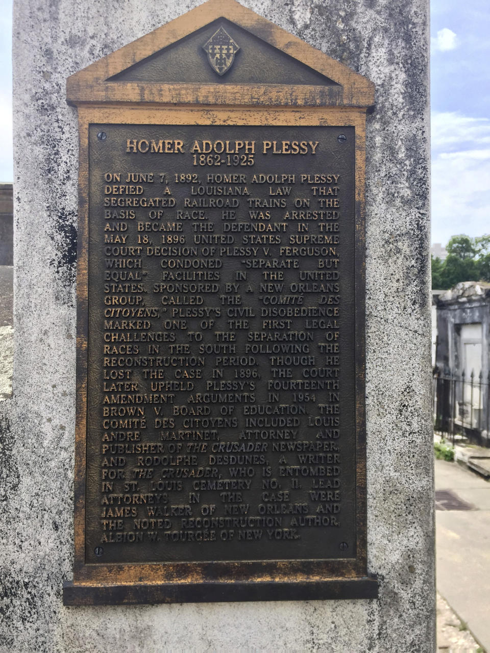 This June 3, 2018 photo shows a marker on the burial site for Homer Plessy at St. Louis No. 1 Cemetery in New Orleans. Plessy was an important figure in U.S. civil rights history. He was of European and African descent and challenged segregation laws, sitting in a train car for whites. The U.S. Supreme Court ruled in 1896 that "separate but equal" accommodations were legal, and that decision, known as Plessy v. Ferguson, stood as a legal justification for segregation until the 1950s. (AP Photo/Beth J. Harpaz)