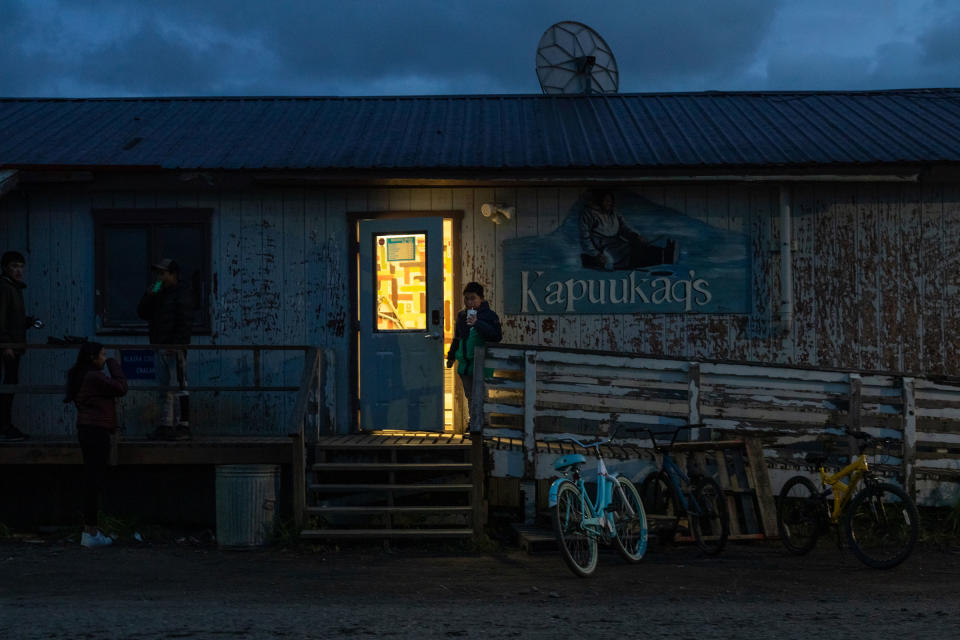 As a group of his friends wait outside, a boy exits a convenience store in Unalakleet, Alaska.<span class="copyright">Acacia Johnson for TIME</span>