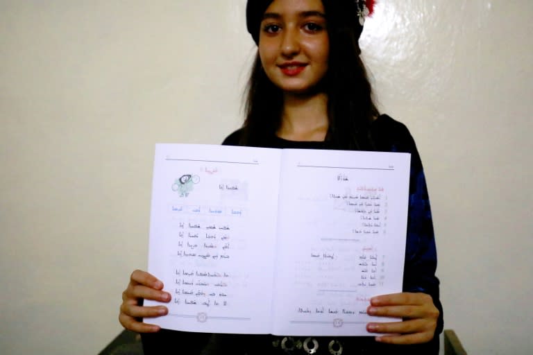 A student from the Syriac Christian minority shows a textbook in her language