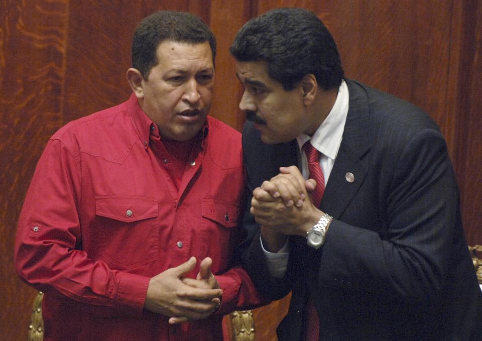 FILE - Venezuela's President Hugo Chavez, left, talks to his Foreign Minister Nicolas Maduro at the University of Uruguay in Montevideo, Uruguay, Dec. 18, 2007. President Hugo Chavez told Venezuelans to choose Maduro as his successor during his last televised message before dying of cancer. Chavez promised them that the leftist policies that oversaw a reduction in poverty would continue under Maduro. But that remains an unfulfilled promise ten years later.. (AP Photo/Matilde Campodonico, File)