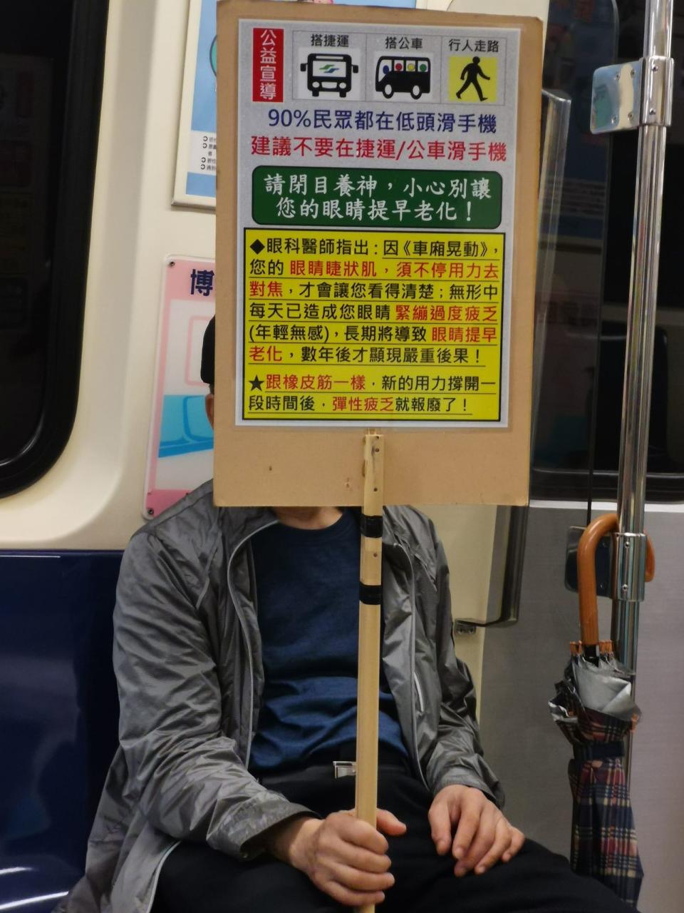 有位坐在博愛座的阿北手舉立牌，提醒大家不要在捷運或公車上滑手機。（翻攝自路上觀察學院）