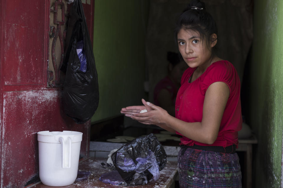 Florinda, 20, from the El Quiche department makes hand-made corn tortillas near La Palmita market in Guatemala City, Saturday, Oct. 16, 2021. Florinda came to the capital four years ago from the western mountainous area and has worked making tortillas ever since. She generally works seven days a week. (AP Photo/Moises Castillo)
