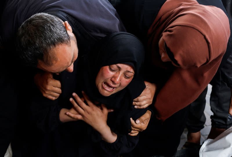 Mourners react next to the bodies of Palestinians killed in Israeli strikes, in Rafah