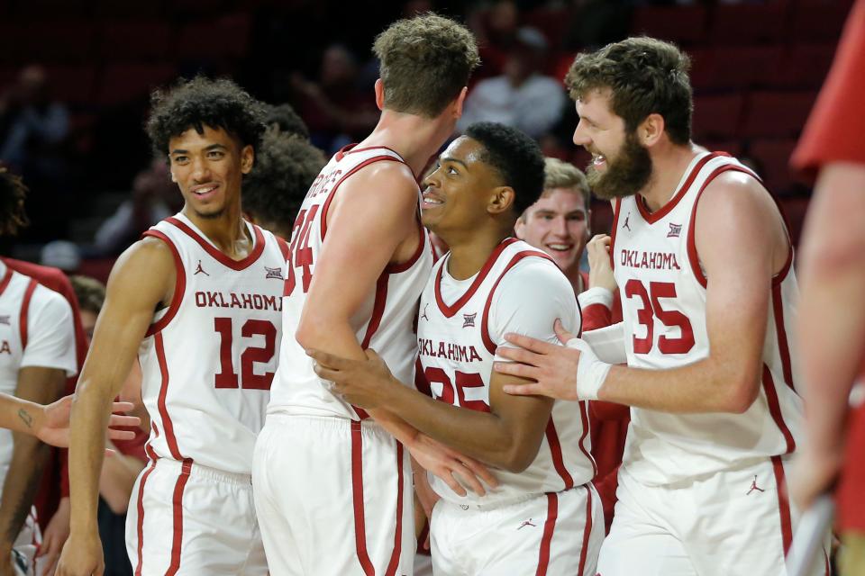 Oklahoma's Grant Sherfield (25) smiles as he celebrates with Milos Uzan (12), Jacob Groves (34) and Tanner Groves (35) after making a 3-pointer and getting fouled during a college basketball game between the University of Oklahoma Sooners (OU) and  UNC Wilmington at Lloyd Noble Center in Norman, Okla., Tuesday, Nov. 15, 2022. Oklahoma won 74-53.