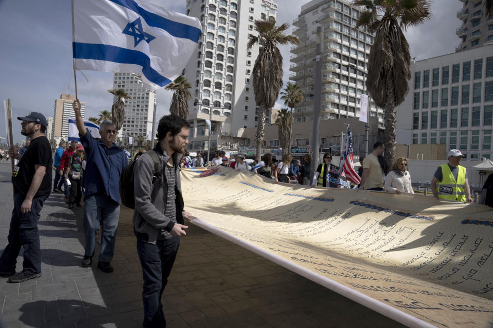 FILE - A representation of Israel's Declaration of Independence is carried by Israeli-Americans outside of the U.S. Embassy Branch Office to protest against plans by Prime Minister Benjamin Netanyahu's new government to overhaul the judicial system, in Tel Aviv, Israel, Tuesday, March 7, 2023. This year, when the slavery-to-freedom story of Passover unfolds, mass demonstrations in Israel will be top of mind for some Jews around the globe. Some Seder hosts plan to recite portions of the Israel Declaration of Independence. Others will connect the traditional symbols on the Seder plate to divisions over Netanyahu's proposed judicial overhaul. (AP Photo/Maya Alleruzzo, File)