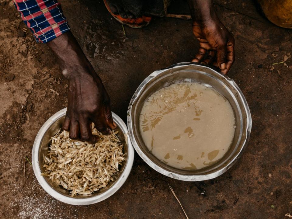 Delly* preparing food for her family at a market in her village (© Hugh Kinsella Cunningham / Save the Children)