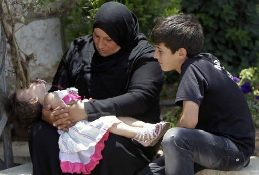 Syrians rest as they wait on the Lebanese-Syrian border in al-Masnaa. Up to 30,000 Syrian refugees may have crossed into Lebanon in the past 48 hours to escape fighting in their country, the United Nations refugee agency UNHCR said