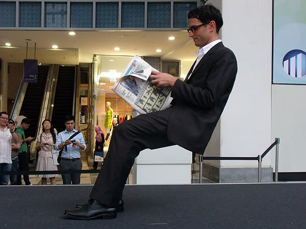 This man was spotted sitting on an "invisible chair" at Raffles Place. (Yahoo! photo/Fann Sim)