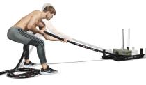 <p>Attach a rope to the sled and grip it tightly with both hands, assuming a wide stance to create a stable base and hinging at the hips. Maintain a straight back as you pull the sled towards you with a hand-over-hand action. Make sure you keep your core tight throughout to avoid swinging your hips excessively. </p>