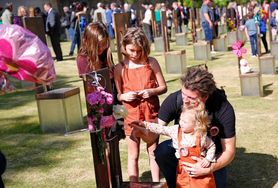 The cousins of Baylee Almon from left, Marlee Hill, Makynzee Hill, Joel Hill and Kobi Hill look at her chair following the 2023 Remembrance Ceremony at the Oklahoma City National Memorial & Museum in Oklahoma City, Wednesday, April, 19, 2023. 