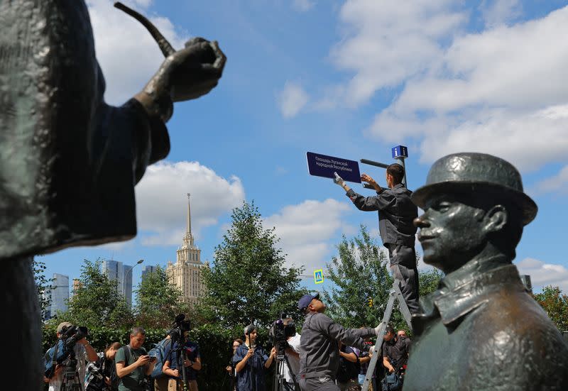 Workers install a direction sign "Luhansk People's Republic Square" in front of the British embassy in Moscow