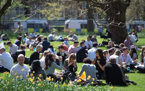 Workers enjoy lunch in the sunshine in Westminster's St James' Park - Credit: Eddie Mulholland