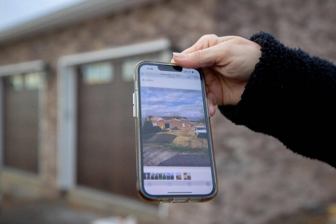 Margaret Whitmer holds a phone on Thursday, Feb. 2, 2023, showing a picture of her home near Millport, Ky., that was destroyed by a tornado on Dec. 10, 2021. Construction is underway on a new home at the site.