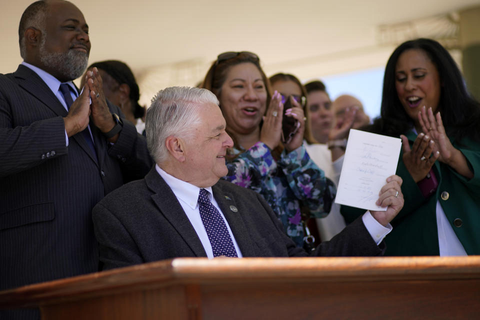 Nevada Democratic Gov. Steve Sisolak holds up a bill newly signed into law Friday, June 11, 2021, in Las Vegas. The law would make Nevada the first to vote on the 2024 presidential primary contests, though national political parties would need to agree to changes in the calendar or state parties could risk losing their delegates at presidential nominating conventions. (AP Photo/John Locher)