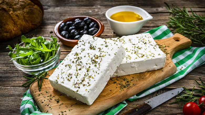 Blocks of feta on board with olives