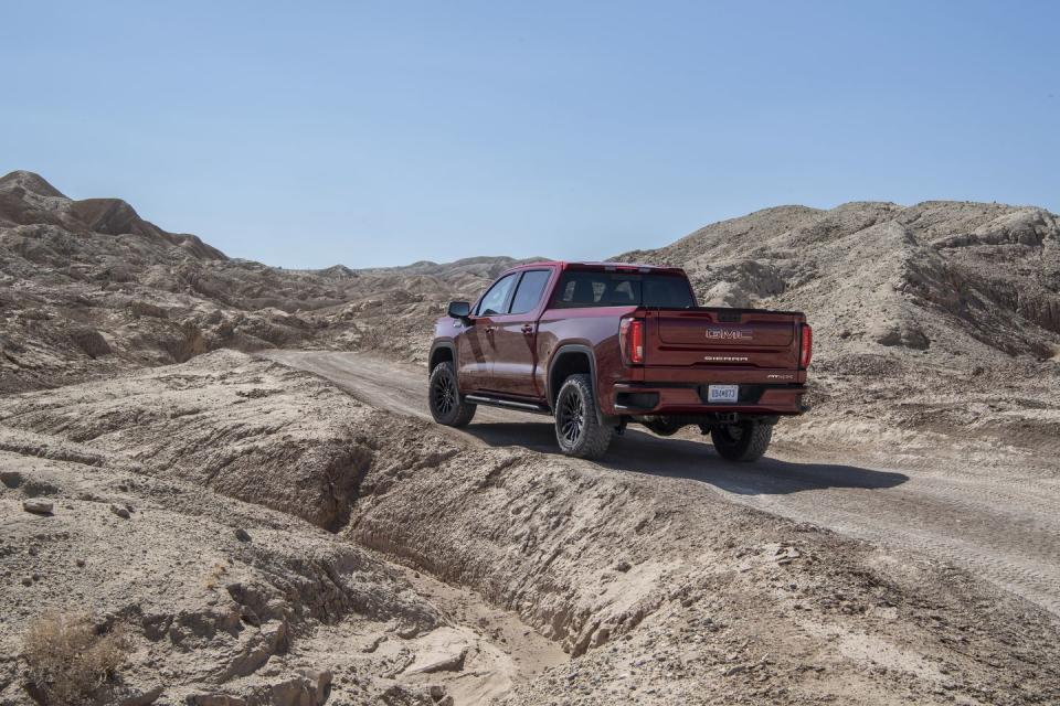 the 2022 gmc sierra at4x parked off road with a rear three quarter view