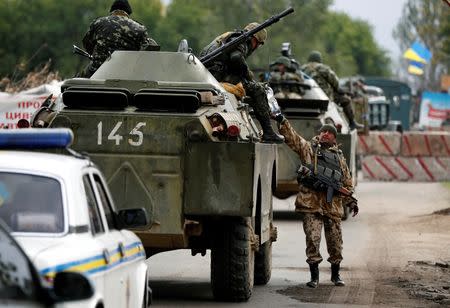 Ukrainian servicemen pass a bottle as they travel on an armoured vehicle near Kramatorsk, September 16, 2014. REUTERS/David Mdzinarishvili