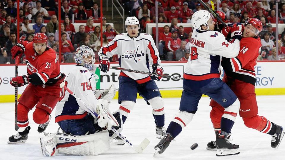 Carolina Hurricanes’ Justin Williams (14) and Washington Capitals’ Matt Niskanen (2) struggle in front of Capitals’ Dmitry Orlov (9), of Russia, and goalie Braden Holtby (70) while Hurricanes’ Nino Niederreiter (21), of the Czech Republic, skates during the third period of an NHL hockey game in Raleigh, N.C., Thursday, March 28, 2019. Washington won 3-2. Gerry Broome/AP