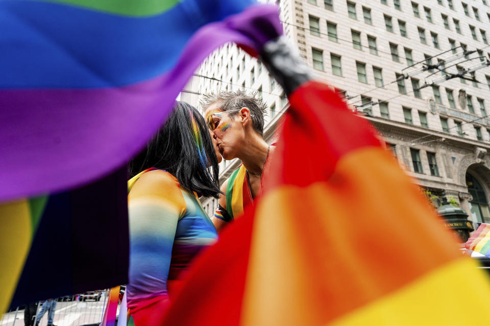 AnMarie Rodgers, derecha, y Jennifer Kanenaga se besan durante el desfile del Orgullo LGBTQ+ el domingo 25 de junio de 2023, en San Francisco. (AP Foto/Noah Berger)