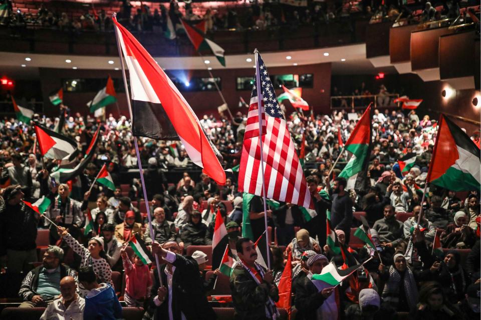 Supporters of “Free Free Palestine” wave Palestinian flags during the community rally in support of freeing Palestine at Ford Community & Performing Arts Center in Dearborn on Tuesday, Oct. 10, 2023. Hamas militants attacked Israel on Saturday, killing more than 900 people, including at least 14 Americans. Israel has responded with a siege and heavy bombing of the Gaza Strip resulting in over 1500 deaths total.
