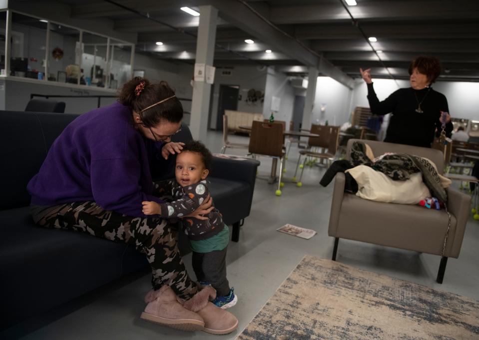 Sarah Wilkinson and son Joseph, 1, in the sitting area of the shelter with Anne Marie Noble, executive director of The Haven of Portage County.