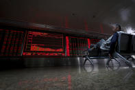 An elderly man sits near an electronic board displaying stock prices at a brokerage house in Beijing, Thursday, Sept. 19, 2019. Shares were mixed in Asia on Thursday, with Tokyo and Sydney logging modest gains after the Federal Reserve cut its benchmark interest rate for a second time this year, citing slowing global economic growth and uncertainty over U.S. trade conflicts. (AP Photo/Andy Wong)