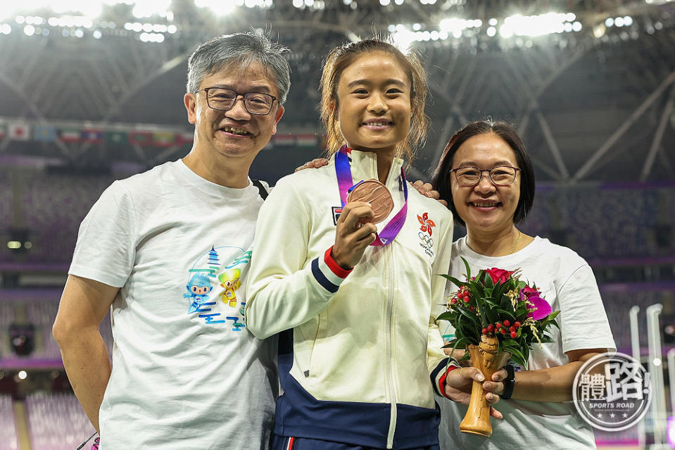 俞雅欣與父母在頒獎台上合照。
