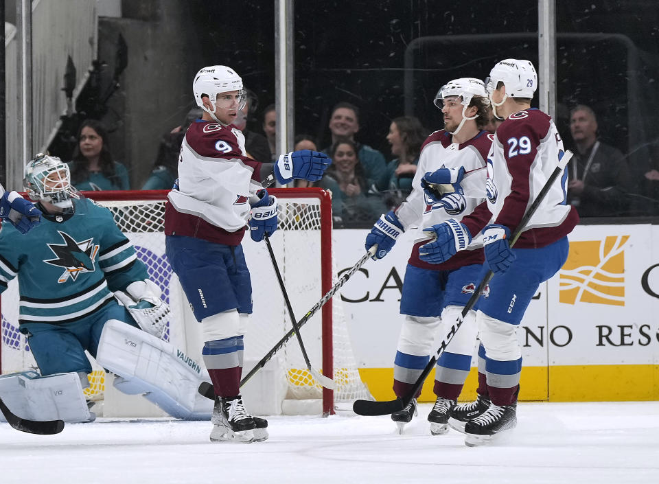 Colorado Avalanche center Evan Rodrigues, front left, is congratulated by Samuel Girard, center, and Nathan MacKinnon (29) after scoring a goal against the San Jose Sharks during the first period of an NHL hockey game Tuesday, April 4, 2023, in San Jose, Calif. (AP Photo/Tony Avelar)