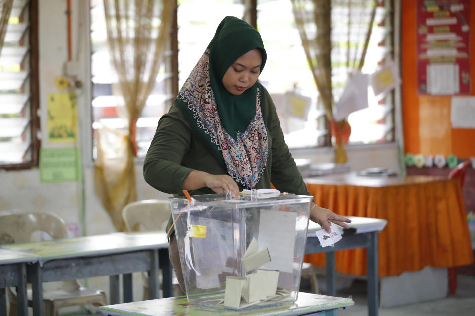 A woman casts her vote during the by-election at a polling station in the southern coastal town of Port Dickson, where Anwar Ibrahim is vying for a seat along with six other candidates, Saturday, Oct. 13, 2018. Voting opened Saturday in a by-election that is expected to see charismatic Malaysian politician Anwar Ibrahim win a parliamentary seat and return to active politics as he prepare for his eventual takeover from Prime Minister Mahathir Mohamad. (AP Photo/Vincent Thian)