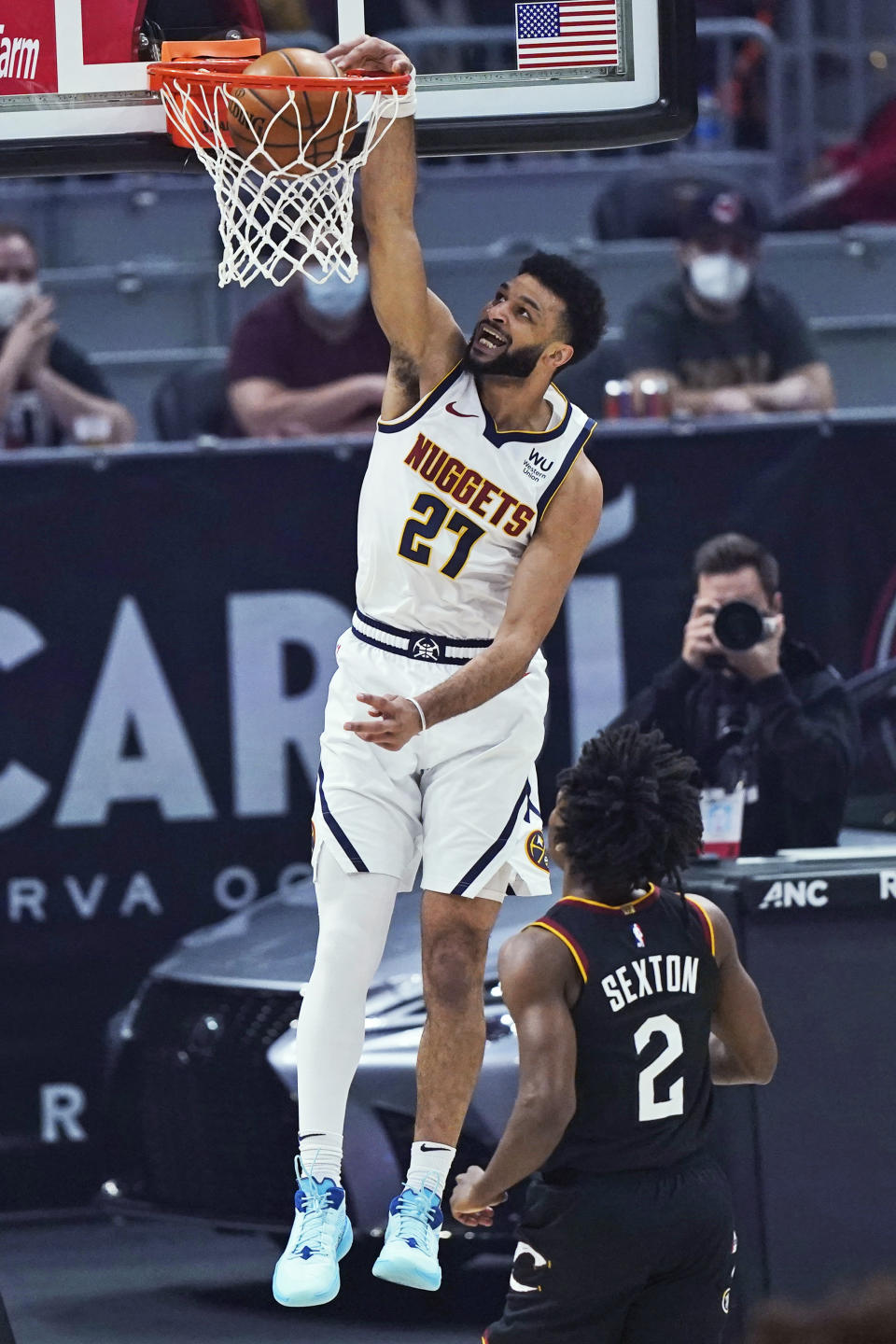 Denver Nuggets' Jamal Murray (27) dunks next to Cleveland Cavaliers' Collin Sexton (2) during the first half of an NBA basketball game Friday, Feb. 19, 2021, in Cleveland. (AP Photo/Tony Dejak)