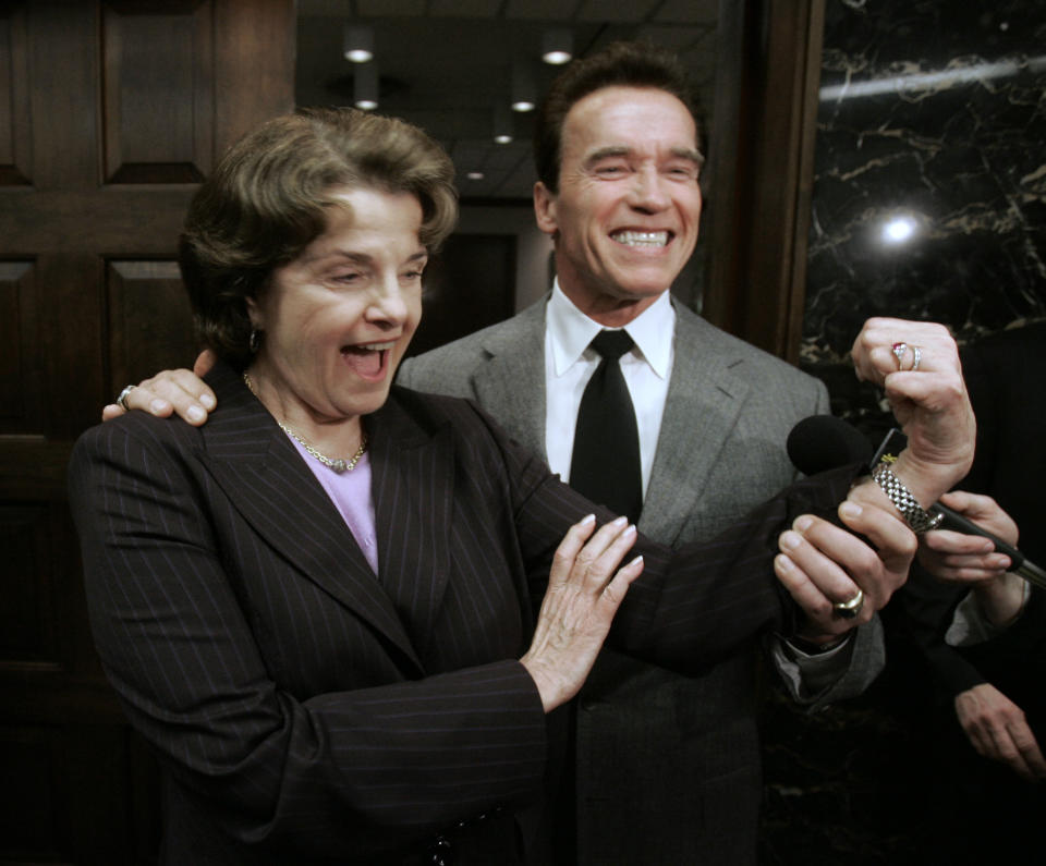 FILE - With the help of Gov. Arnold Schwarzenegger, U.S. Sen. Dianne Feinstein flexes her bicep to show the muscle she will use to help Schwarzenegger come up with a water plan during a news conference at the Capitol, in Sacramento, Calif., Thursday, Feb. 21, 2008. Feinstein met with Schwarzenegger and legislative leaders to help restart talks in an effort to come with comprehensive water plan for California. (AP Photo/Rich Pedroncelli, File)