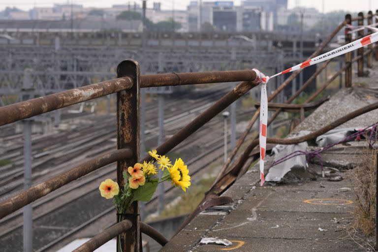 Un ramo de flores de plástico en el lugar del accidente de un autobús de pasajeros en Mestre, cerca de la ciudad de Venecia, Italia, el miércoles 4 de octubre de 2023. El autobús cayó desde una carretera elevada la noche del martes, matando a varias personas. (AP Foto/Antonio Calanni)