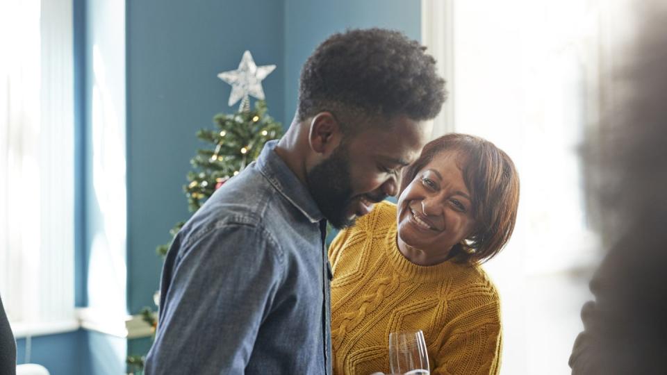 smiling friends talking while standing in christmas party at home