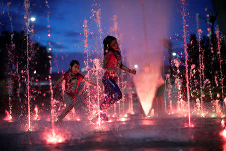 Honduran children, part of a caravan of thousands of migrants from Central America en route to the United States, play with water fountains on the sidewalks of Tapachula city center, Mexico October 21, 2018. REUTERS/Ueslei Marcelino